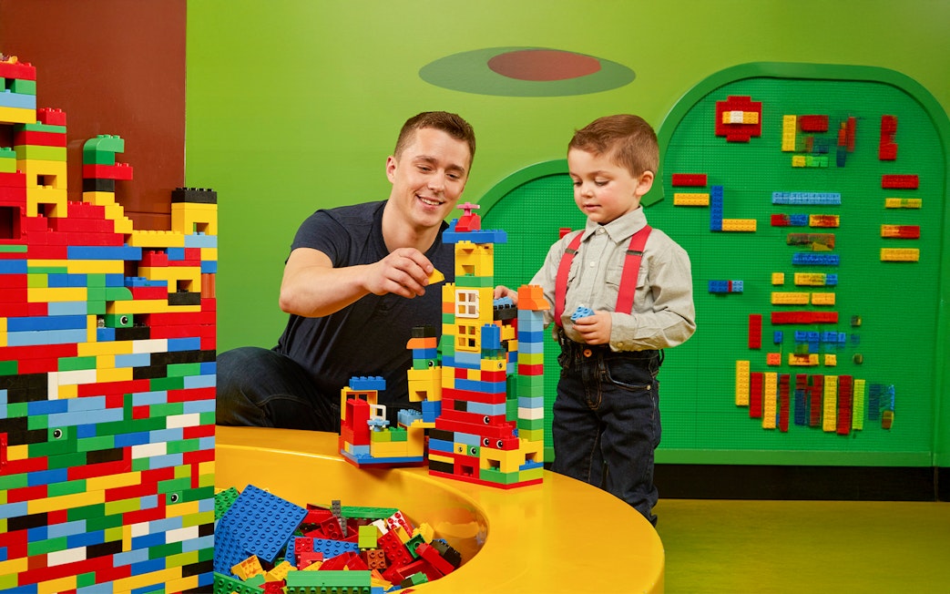 Father and child building Lego towers at LEGOLAND Discovery Centre Oberhausen.
