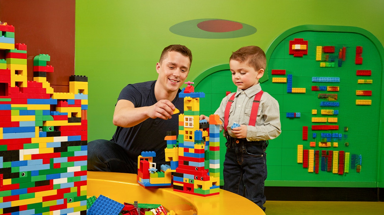 Father and child building Lego towers at LEGOLAND Discovery Centre Oberhausen.