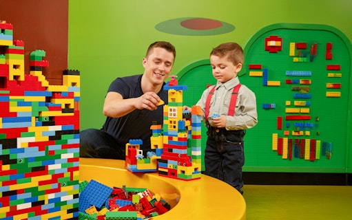 Father and child building Lego towers at LEGOLAND Discovery Centre Oberhausen.