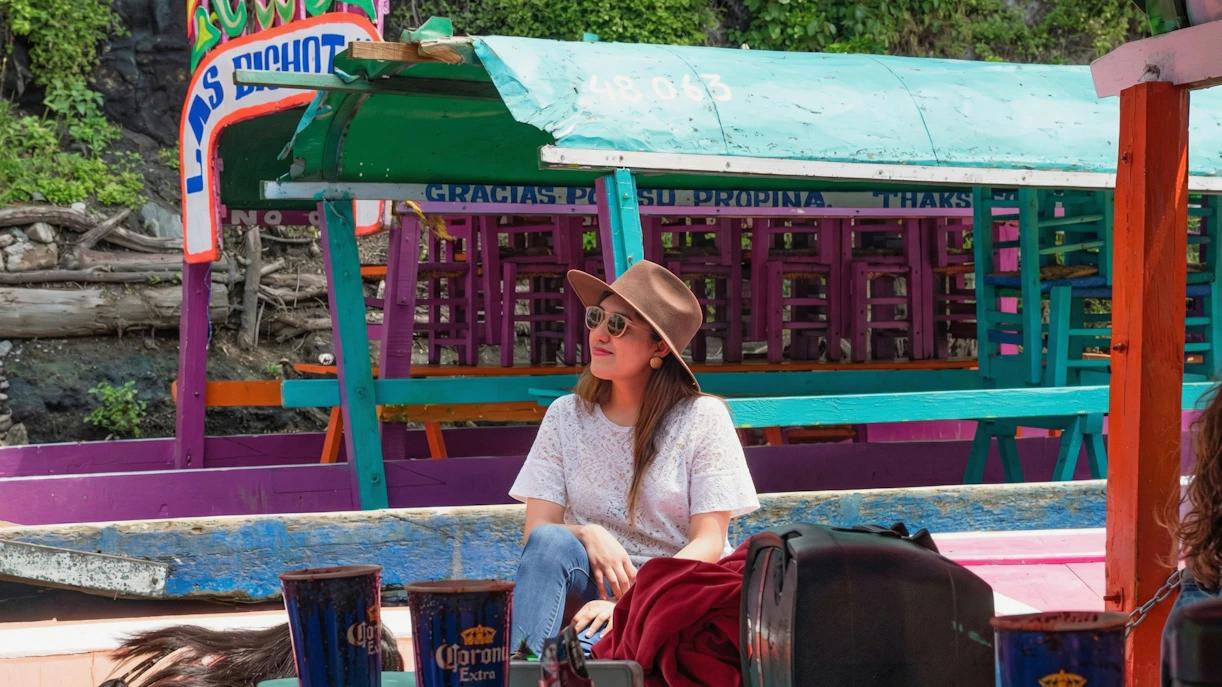 Xochimilco trajinera with colorful decorations and a person enjoying the ride.