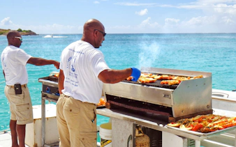 Grilling seafood on a catamaran near Ile aux Cerf, Mauritius.
