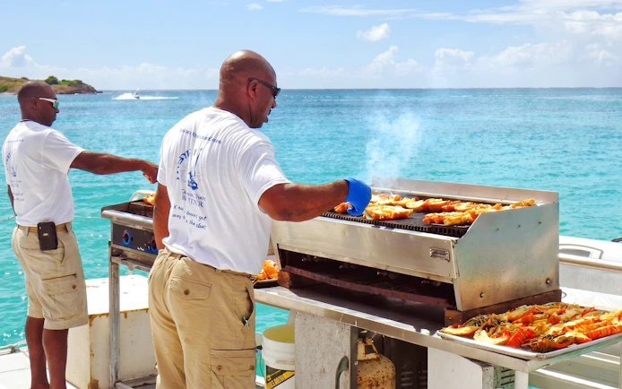 Grilling seafood on a catamaran near Ile aux Cerf, Mauritius.