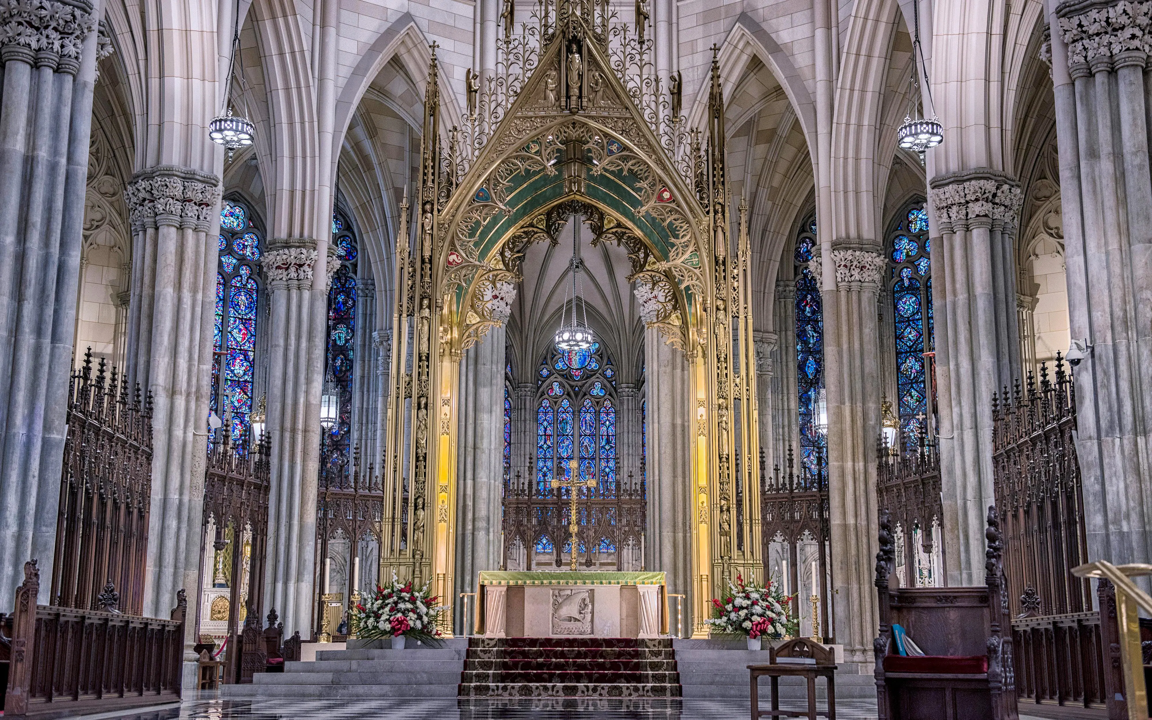 Stained glass windows and ornate altar inside St Patrick Cathedral, New York City.
