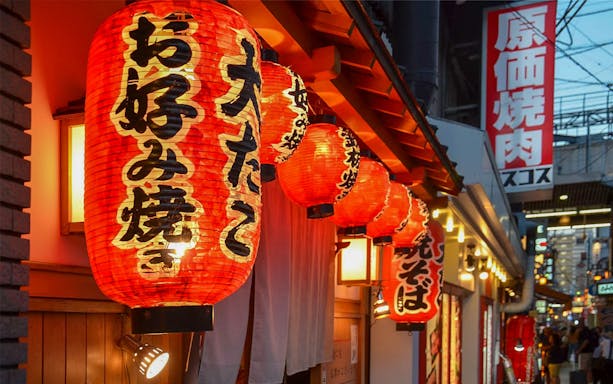 Red lanterns outside a restaurant in Osaka during a night food tour.