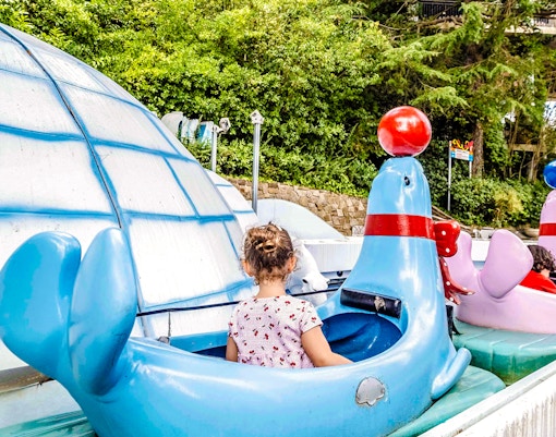 Children riding seal-shaped boats at Alaska ride, Tibidabo Amusement Park.