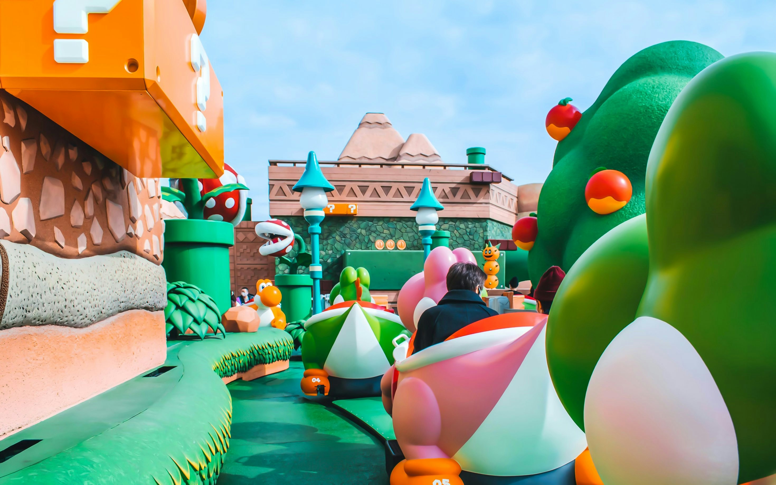Visitors riding Yoshi-themed attraction at Super Nintendo World, Universal Studios Japan, Osaka.