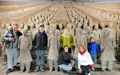 Visitors posing with Terracotta Warriors at the museum on a half-day group tour from Chengdu.