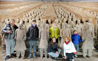 Visitors posing with Terracotta Warriors at the museum on a half-day group tour from Chengdu.