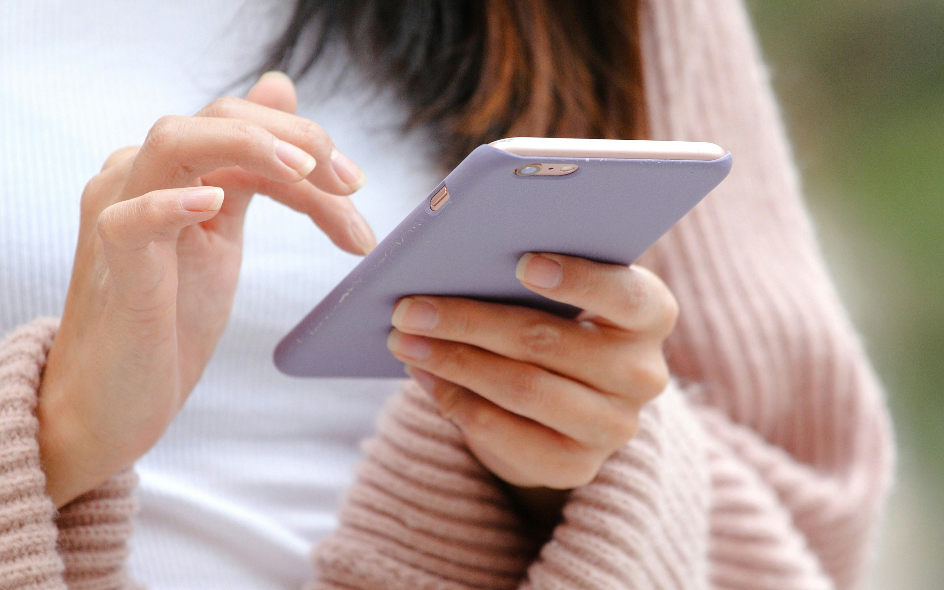 Close-up of hands using a mobile phone.