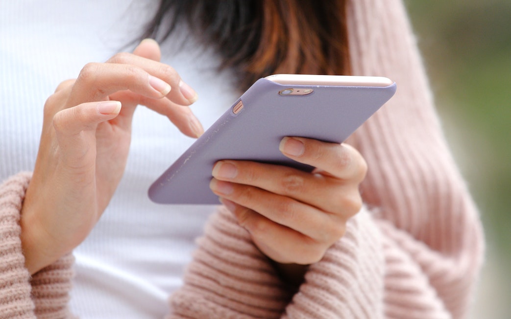 Close-up of hands using a mobile phone.