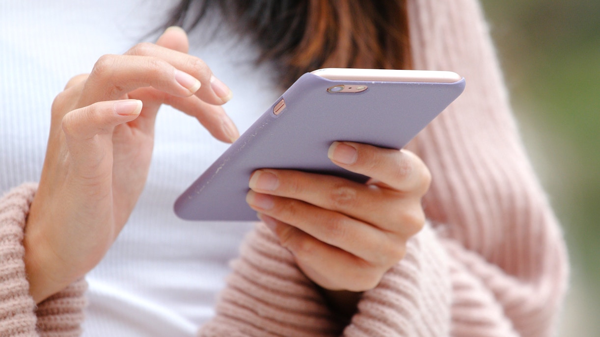 Close-up of hands using a mobile phone.