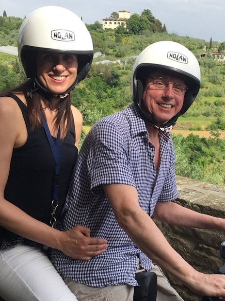 Couple riding a Vespa through the Tuscan countryside on a guided tour from Florence.