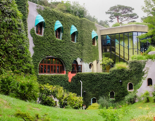 Ghibli Museum exterior facade covered in ivy with unique window designs in Mitaka, Japan.