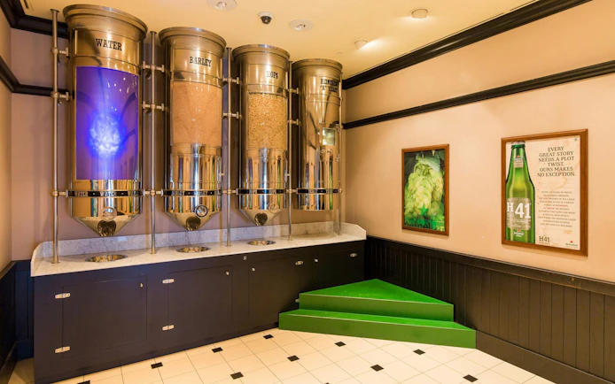 Heineken Experience Amsterdam brewing ingredients display with water, barley, hops, and yeast.