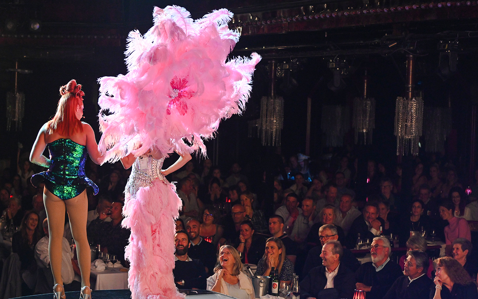 Performers on stage at Paradis Latin cabaret in Paris, with audience watching.