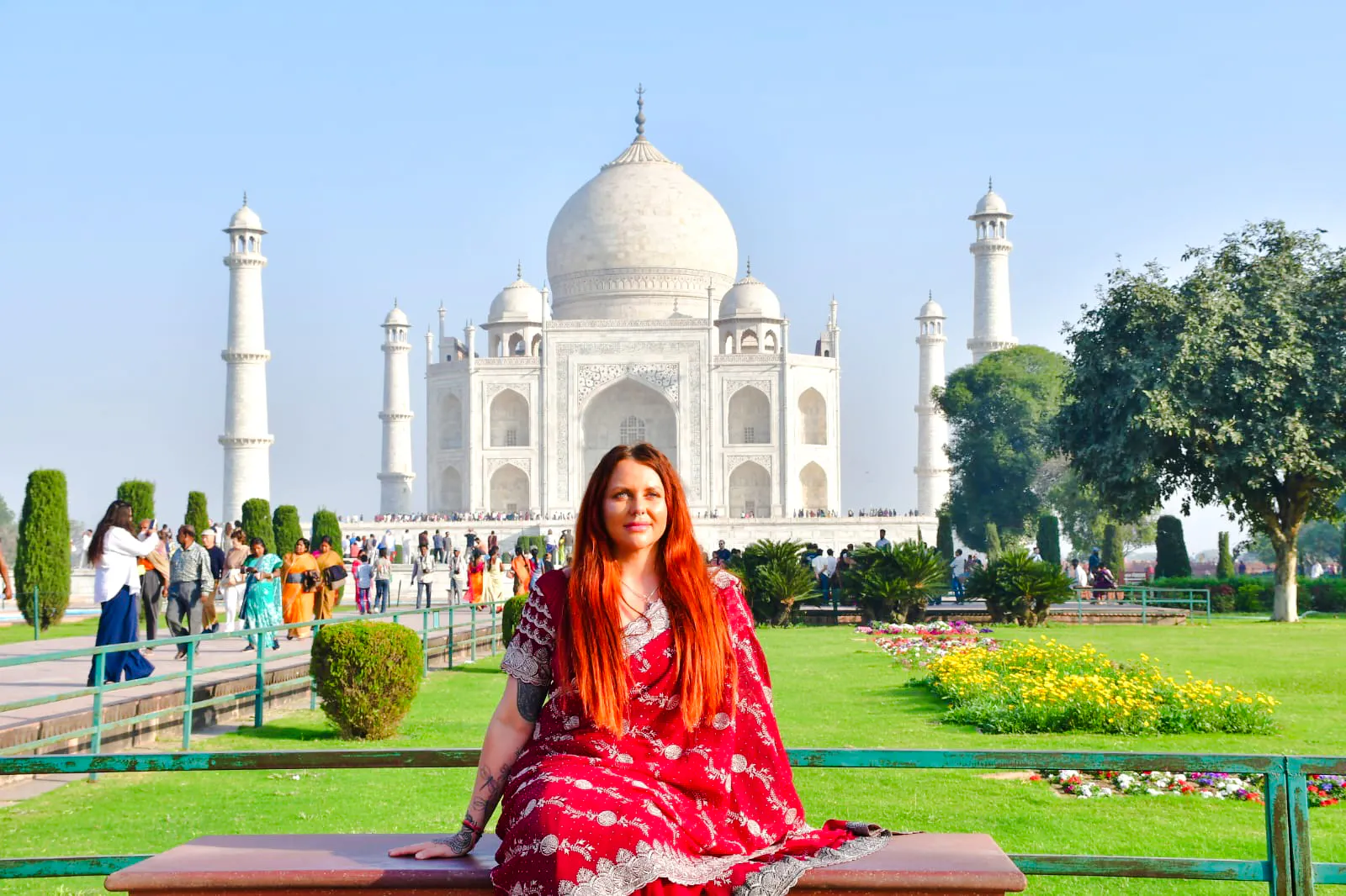 Sunrise view of the Taj Mahal with a visitor in traditional attire, Agra tour.