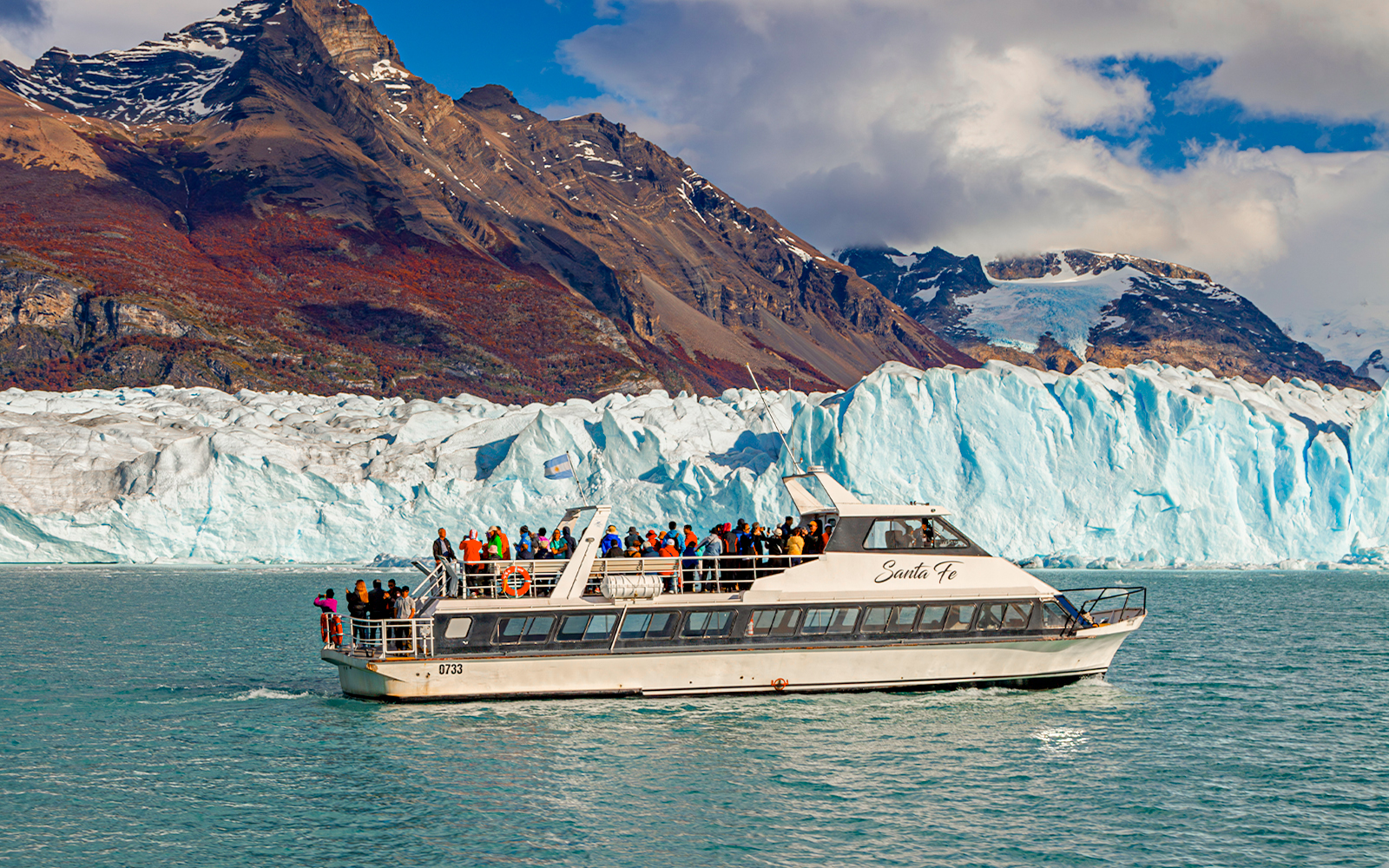 Cruise ship in front of Perito Moreno Glacier, Argentina, with tourists on deck.