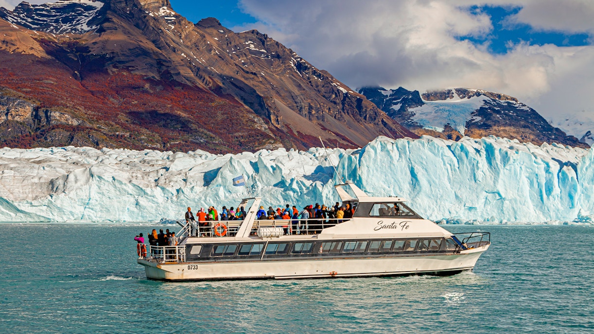 Cruise ship in front of Perito Moreno Glacier, Argentina, with tourists on deck.