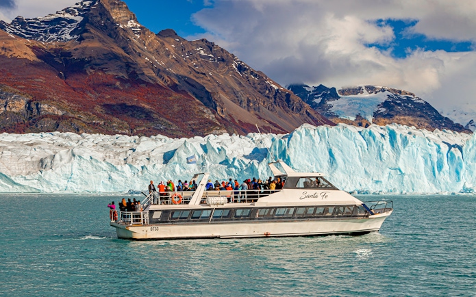Cruise ship in front of Perito Moreno Glacier, Argentina, with tourists on deck.