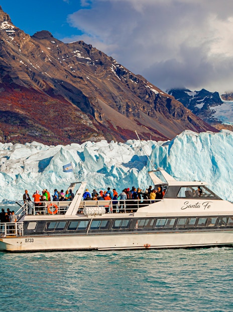 Cruise ship in front of Perito Moreno Glacier, Argentina, with tourists on deck.
