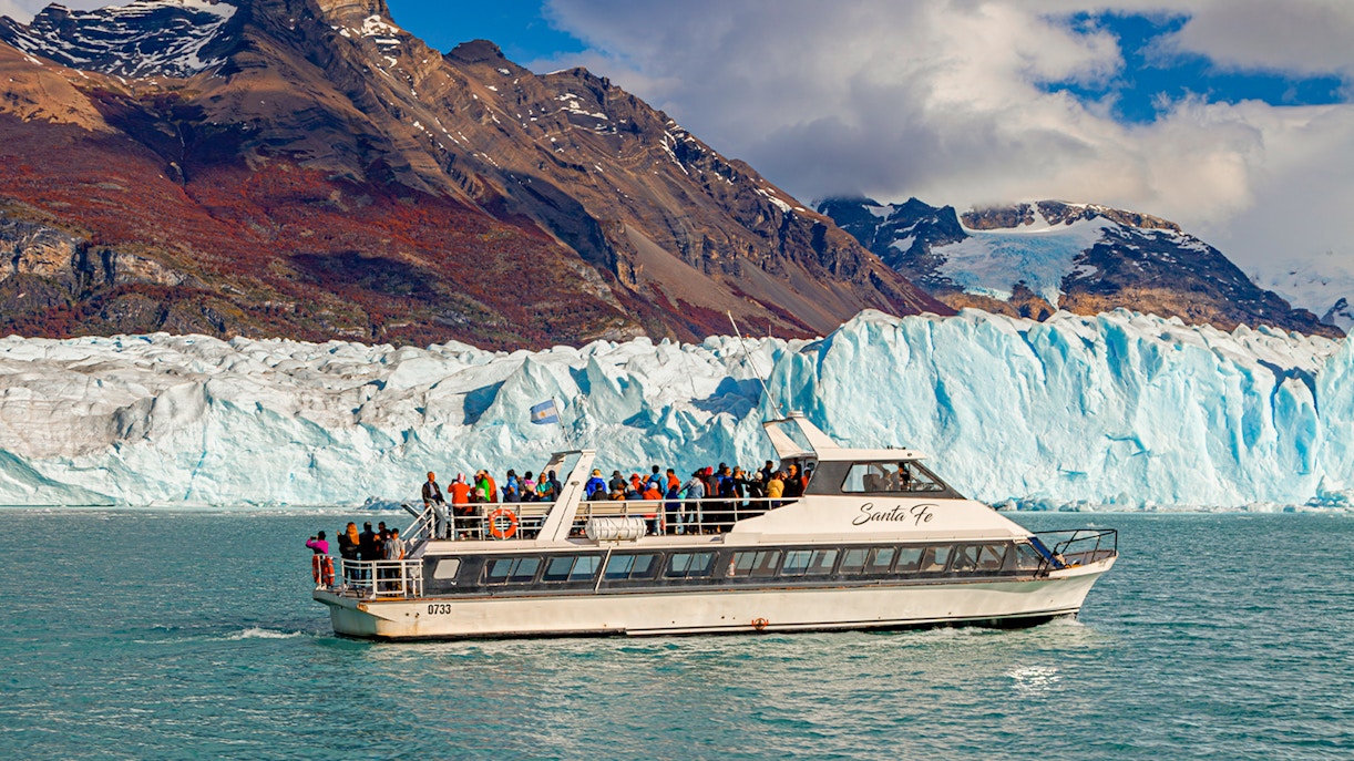 Cruise ship in front of Perito Moreno Glacier, Argentina, with tourists on deck.