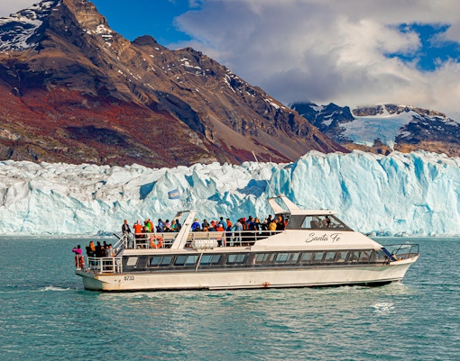 Cruise ship in front of Perito Moreno Glacier, Argentina, with tourists on deck.