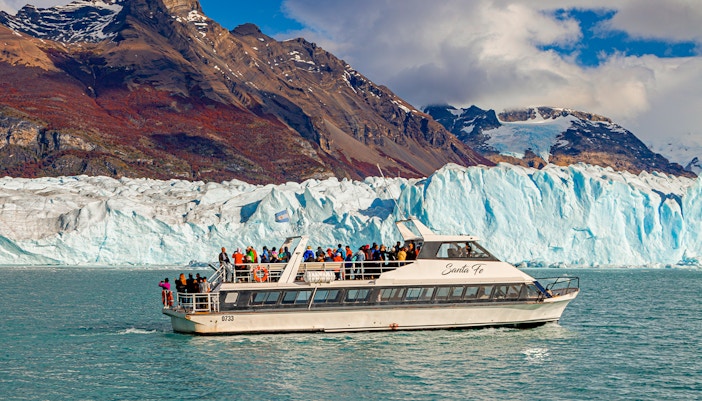 Cruise ship in front of Perito Moreno Glacier, Argentina, with tourists on deck.