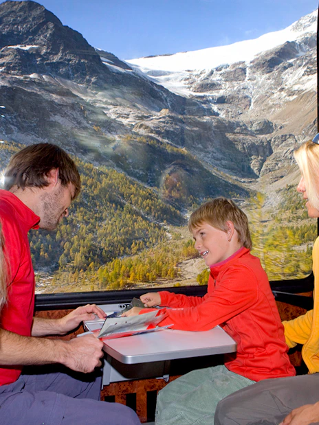 Family enjoying scenic views on the Bernina Express in Switzerland with Interrail pass.