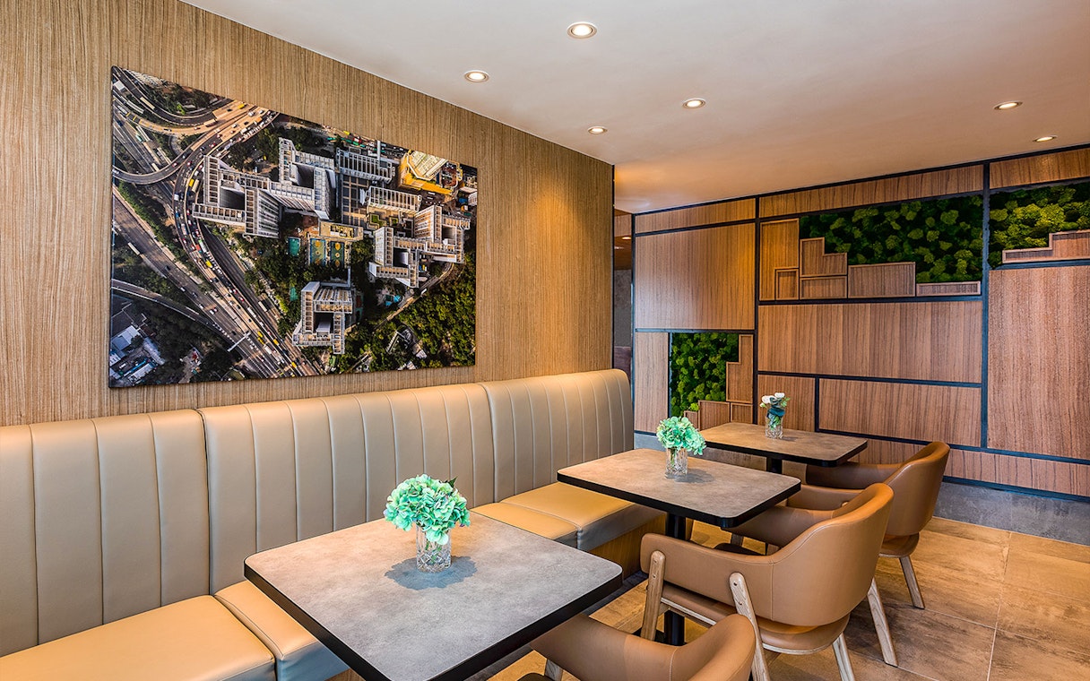 Seating area in Plaza Premium Lounge with aerial cityscape artwork on the wall.