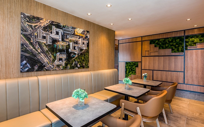 Seating area in Plaza Premium Lounge with aerial cityscape artwork on the wall.