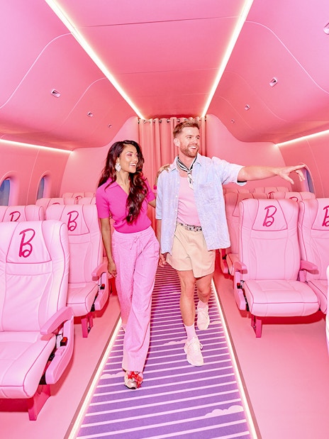 Guests exploring Barbie-themed airplane interior at The Dream Experience in Amsterdam.