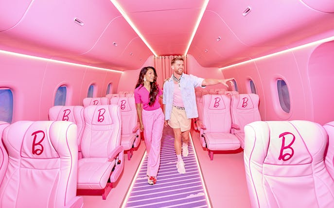 Guests exploring Barbie-themed airplane interior at The Dream Experience in Amsterdam.