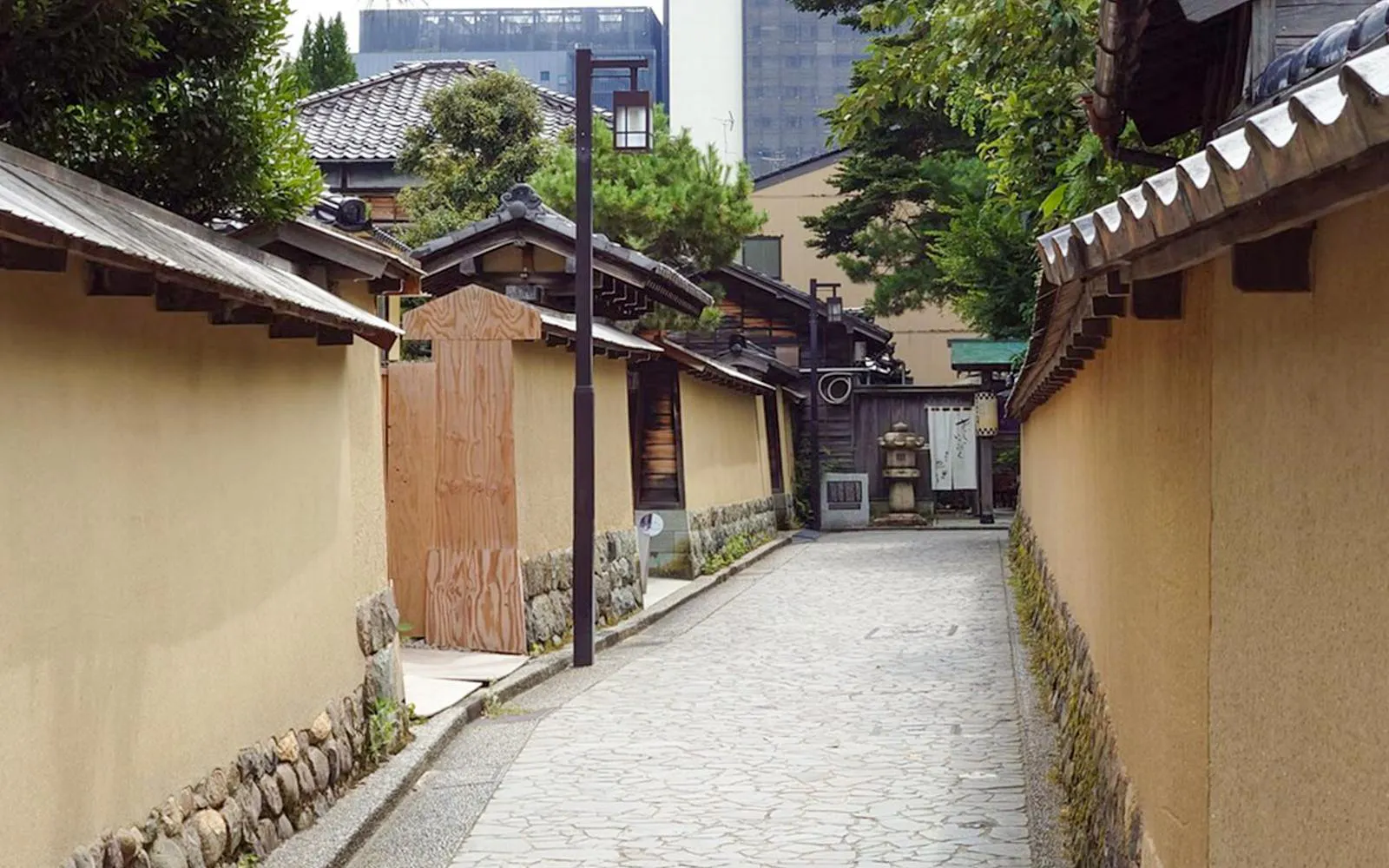Traditional street in Kanazawa with historic wooden buildings and stone pathway.