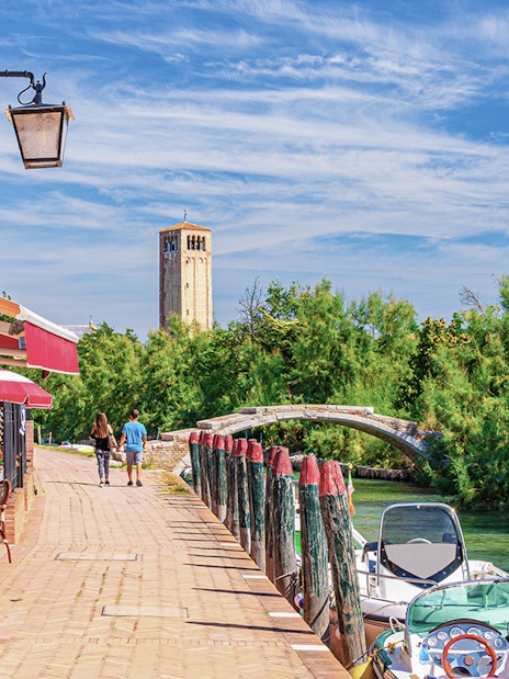 Torcello Island's Devil Bridge with nearby canal and walking path.
