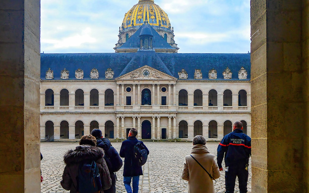 Visitors at Les Invalides courtyard with the Dome in Paris on Napoleon's Legacy Tour.