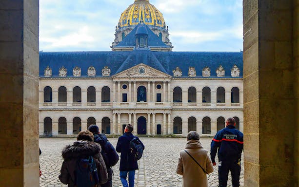 Visitors at Les Invalides courtyard with the Dome in Paris on Napoleon's Legacy Tour.