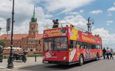 Hop-on hop-off bus near Royal Castle in Warsaw, part of 24/48/72-hour tour package.