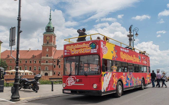 Hop-on hop-off bus near Royal Castle in Warsaw, part of 24/48/72-hour tour package.
