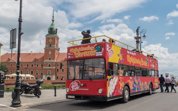 Hop-on hop-off bus near Royal Castle in Warsaw, part of 24/48/72-hour tour package.