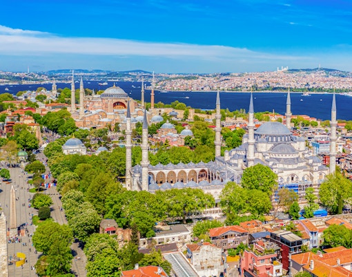 Hagia Sophia and Blue Mosque in Sultanahmet district, Istanbul, with tourists exploring the historic architecture.