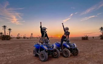 Quad bike riders in the palm grove at sunset, Marrakech.