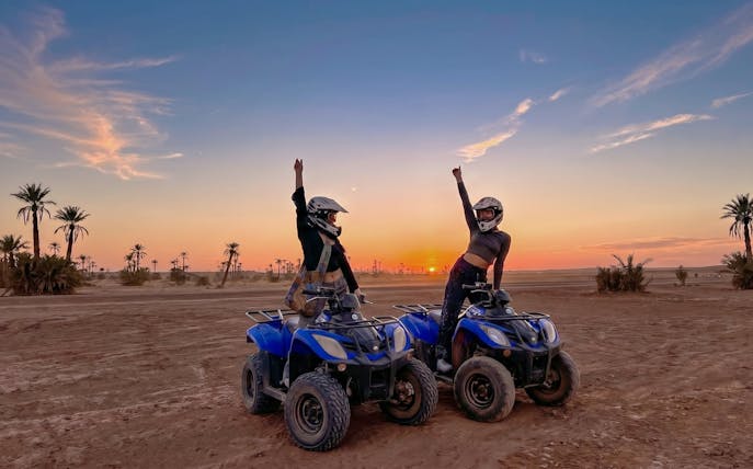 Quad bike riders in the palm grove at sunset, Marrakech.