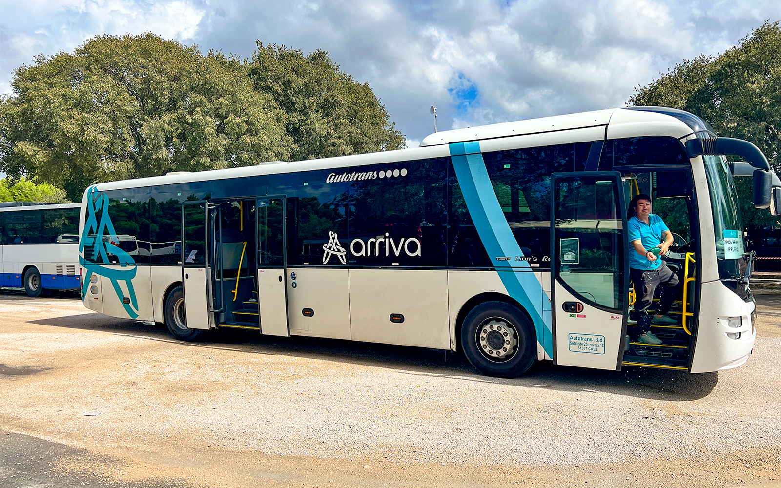 Bus for transfers to Krka National Park with driver at the door.
