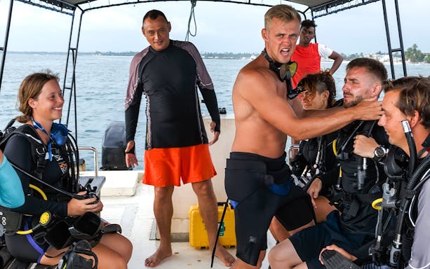 Divers on a boat preparing to swim to a dive site.