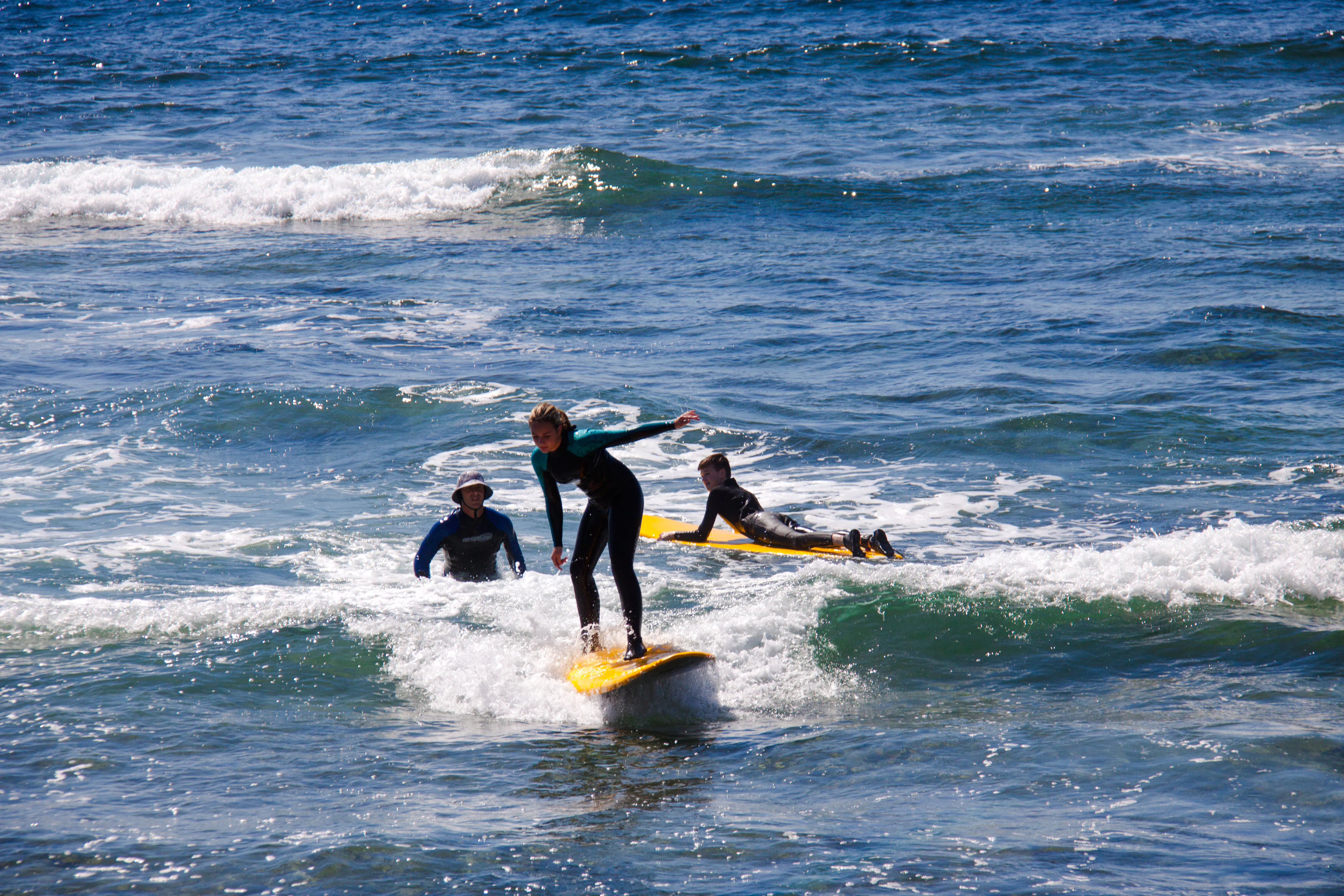 Beginner surfers learning on small waves in Taghazout with equipment.