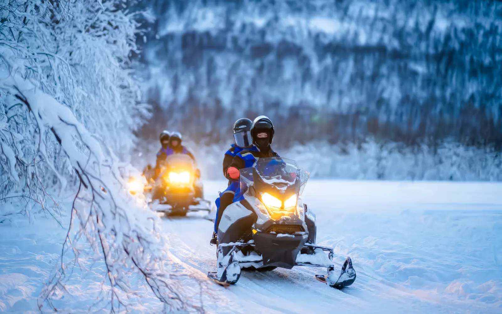 Snowmobiles on snowy trail during small-group day trip in Tromso.