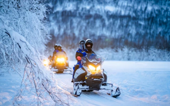 Snowmobiles on snowy trail during small-group day trip in Tromso.