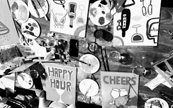 Participants painting canvases with "Happy Hour" and "Cheers" at a Barcelona sip and paint night.