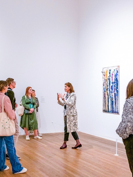 Group listening to a guide inside Tate Modern gallery.