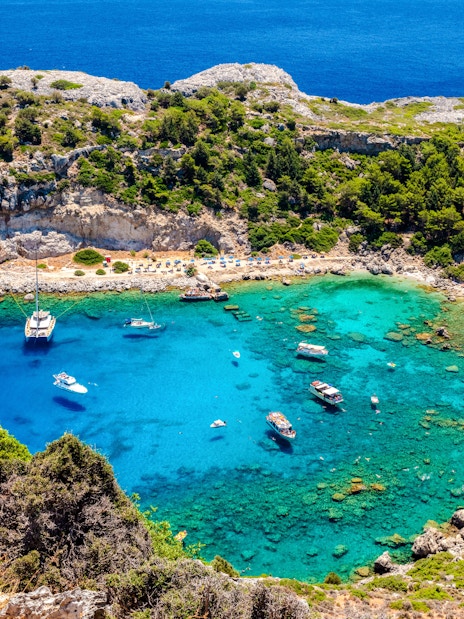 Boats anchored in the turquoise waters of Anthony Quinn Bay, Rhodes Island, Greece.